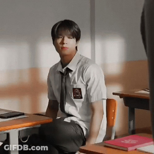 Boy In School Uniform Sitting At Desk GIF