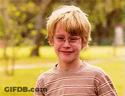 Boy In Striped Shirt And Glasses Smiling In Park GIF
