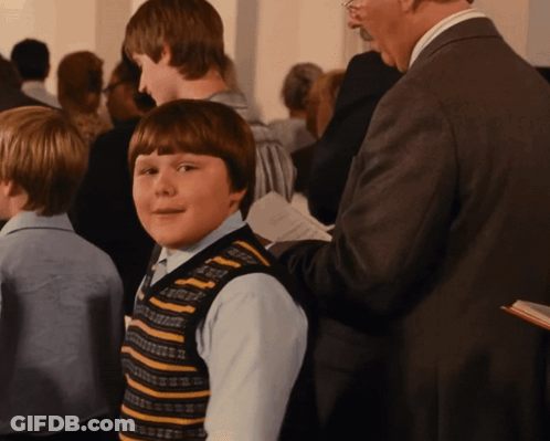 Boy In Striped Vest Standing In Crowd GIF