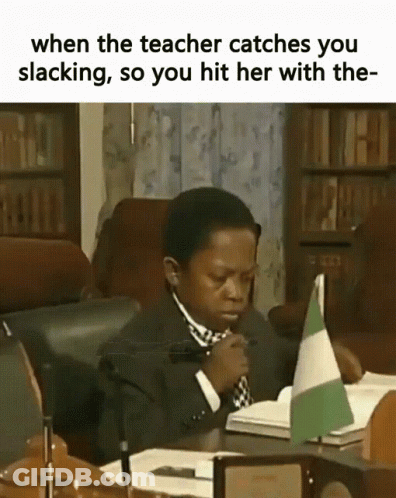 Boy In Suit And Tie Sitting At Desk With Book And Flag GIF
