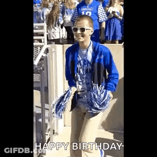Boy In Sunglasses And Blue Jacket Holding Pom Poms GIF