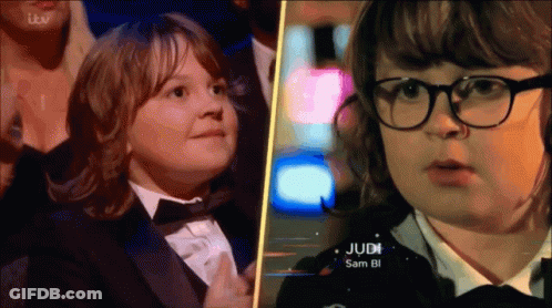 Boy In Tuxedo Next To Girl With Glasses GIF