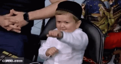 Boy In White Shirt And Black Hat Sitting GIF