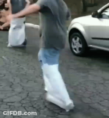 Boy In White Shirt And Black Shorts Walking On Brick Walkway GIF