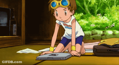 Boy In White Shirt And Blue Shorts Kneeling By Laptop GIF