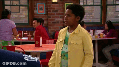 Boy In Yellow Jacket Standing In Diner With Disney GIF