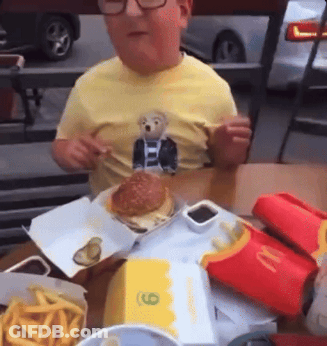 Boy In Yellow Shirt Eating Hamburger At McDonald's GIF