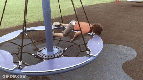 Boy Lying On Blue And Purple Merry Go Round GIF