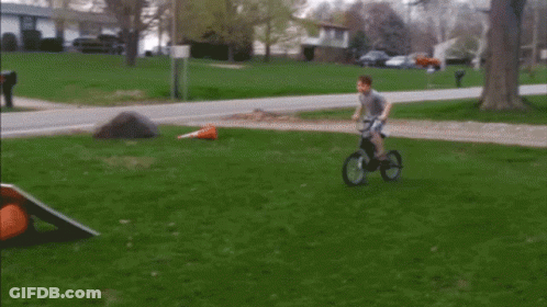 Boy Riding Bike On Grass GIF