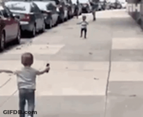 Boy Riding Scooter Down Sidewalk GIF