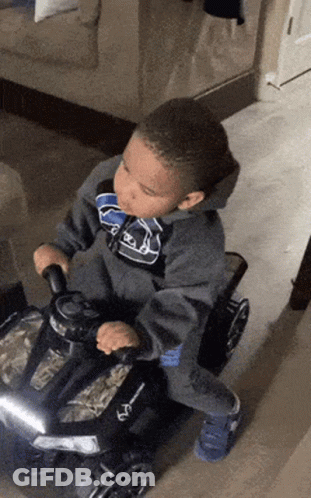 Boy Riding Toy Car In Living Room GIF