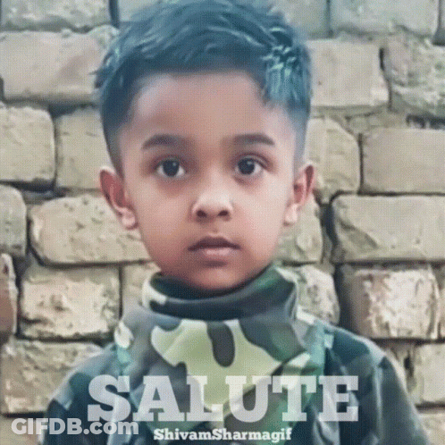 Boy Saluting In Front Of Brick Wall GIF