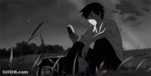 Boy Sitting In Grass Looking At Phone GIF