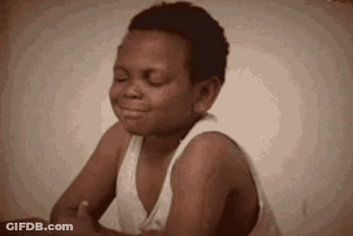 Boy Sitting With Eyes Closed In White Tank Top GIF