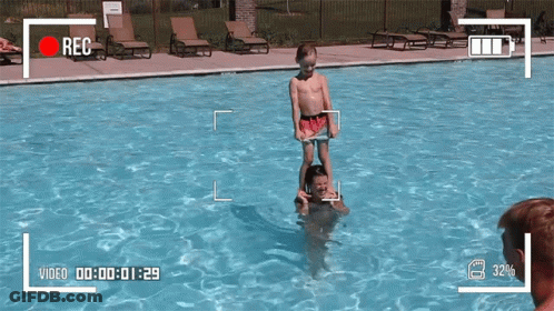 Boy Standing On Man's Shoulders In Pool GIF
