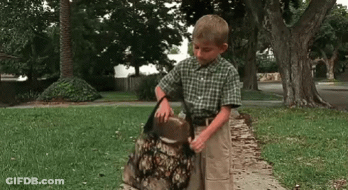 Boy Standing On Sidewalk Holding Bag GIF