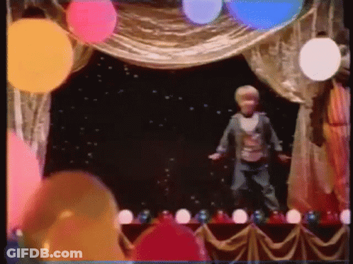 Boy Standing On Stage With Balloons GIF