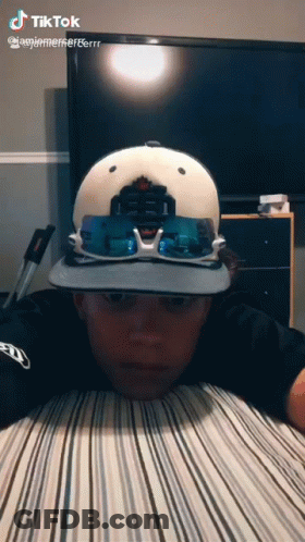 Boy Wearing Hat And Sunglasses Lying On Bed GIF
