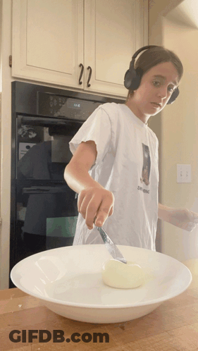 Boy Wearing Headphones Cutting Dough GIF