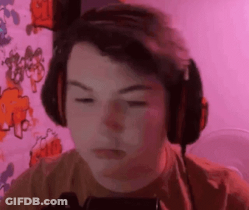 Boy Wearing Headphones Looking At Phone GIF