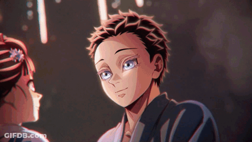 Boy With Blue Eyes Standing Next To Woman With Flower In Hair GIF