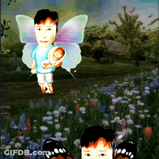 Boy With Butterfly Wings Holding Baby In Field GIF