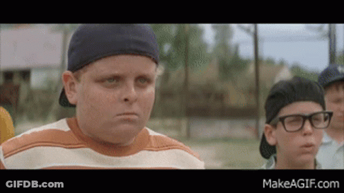 Boy With Glasses And Baseball Cap Standing Next To Another Boy GIF