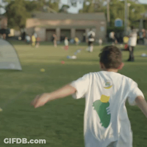 Boy With Green And Yellow Design Shirt Running In Field GIF