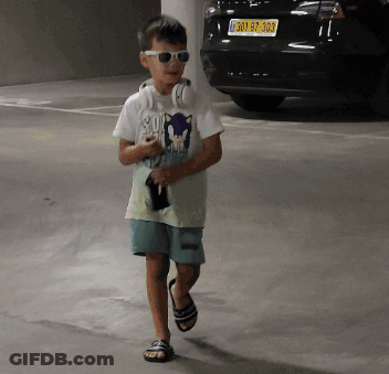 Boy With Headphones And Sunglasses Walking In Parking Garage GIF