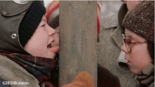 Boy With Helmet Sticking Tongue Out At Girl With Glasses GIF