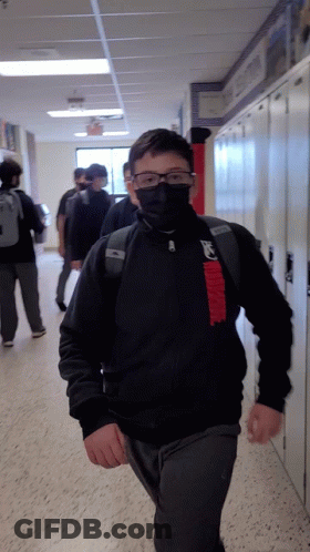 Boy With Mask And Glasses Walking Hallway GIF