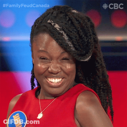 Braided Woman Smiling In Red Shirt With Jamaica Badge GIF
