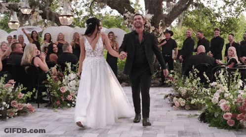 Bride And Groom Holding Hands Down Aisle GIF