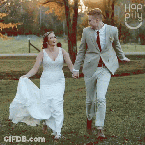 Bride And Groom Holding Hands In Field GIF