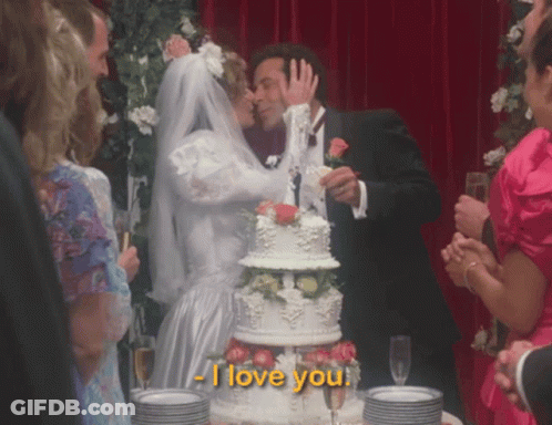 Bride And Groom Kiss In Front Of I Love You Cake GIF