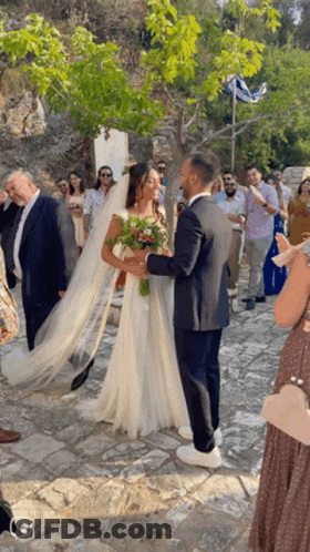 Bride And Groom Posing In Front Of Crowd GIF