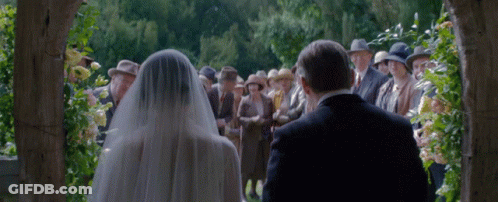Bride And Groom Walking Down Aisle With Father GIF