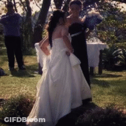 Bride In White Wedding Dress Standing In Grass GIF