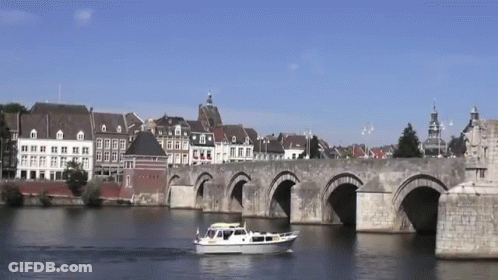 Bridge Over Water With Boat In Foreground GIF