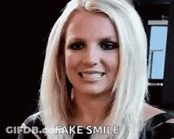 Britney Spears Is Smiling And Making A Fake Smile With Her Mouth Open . GIF