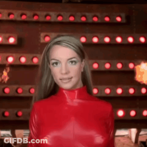 Britney Spears Is Wearing A Red Latex Outfit In Front Of A Wall Of Lights . GIF