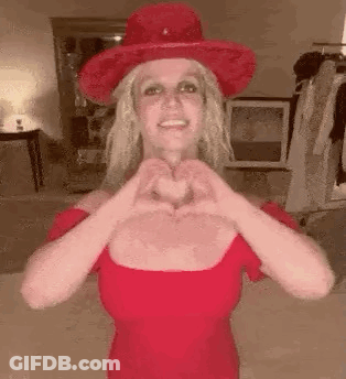 Britney Spears Making Heart Shape In Red Dress And Red Hat GIF
