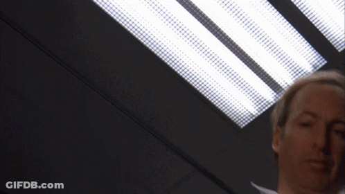 Brown Jacket White Shirt Man Under Ceiling Light GIF