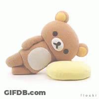 Brown Teddy Bear Laying On Yellow Pillow GIF