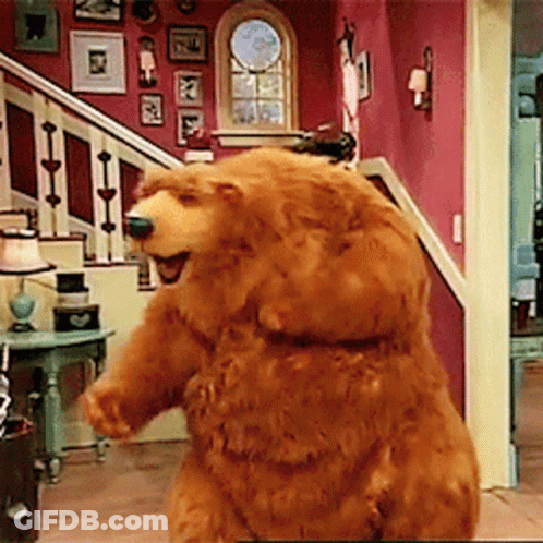 Brown Teddy Bear Standing In Living Room In Front Of Stairs GIF