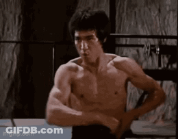 Bruce Lee Flexing Muscles In Boxing Ring GIF