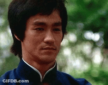 Bruce Lee Is Wearing A Blue Shirt With A White Collar GIF