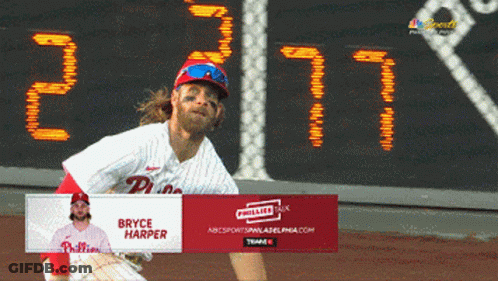 Bryce Harper Throws A Ball In Front Of A Scoreboard GIF