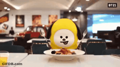 BT21 Stuffed Animal At Table With Food And Sign GIF
