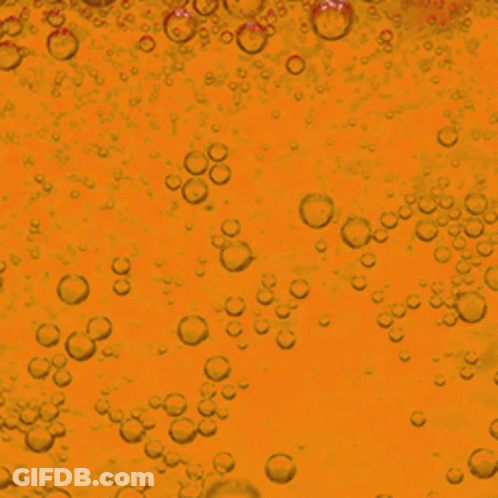 Bubbles Are Floating In A Yellow Liquid GIF